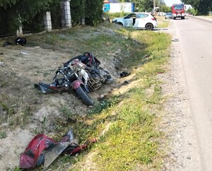 motocykl w przydrożnym rowie, dalej pojazd osobowy i straż