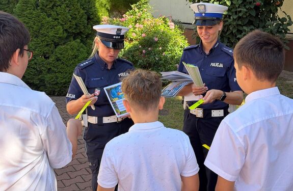 policjantki rozdają odblaski dzieciom przed szkołą