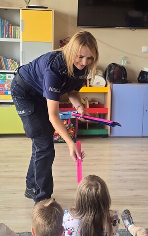 policjantka wręcza odblaski dzieciom