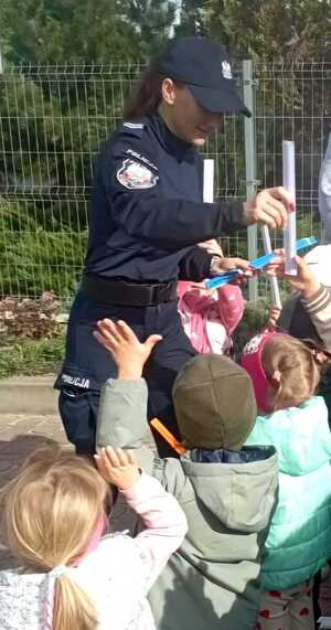 policjantka wręcza dzieciom odblaski