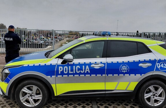 policjant i radiowóz w rejonie cmentarza